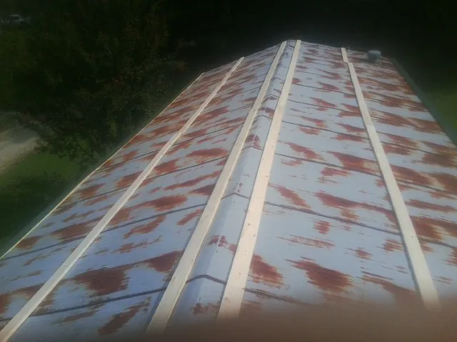 Rusted metal roof panels with new wood purlins before replacement — Storm Damage Roof Repair in Neville by Roofing Brothers